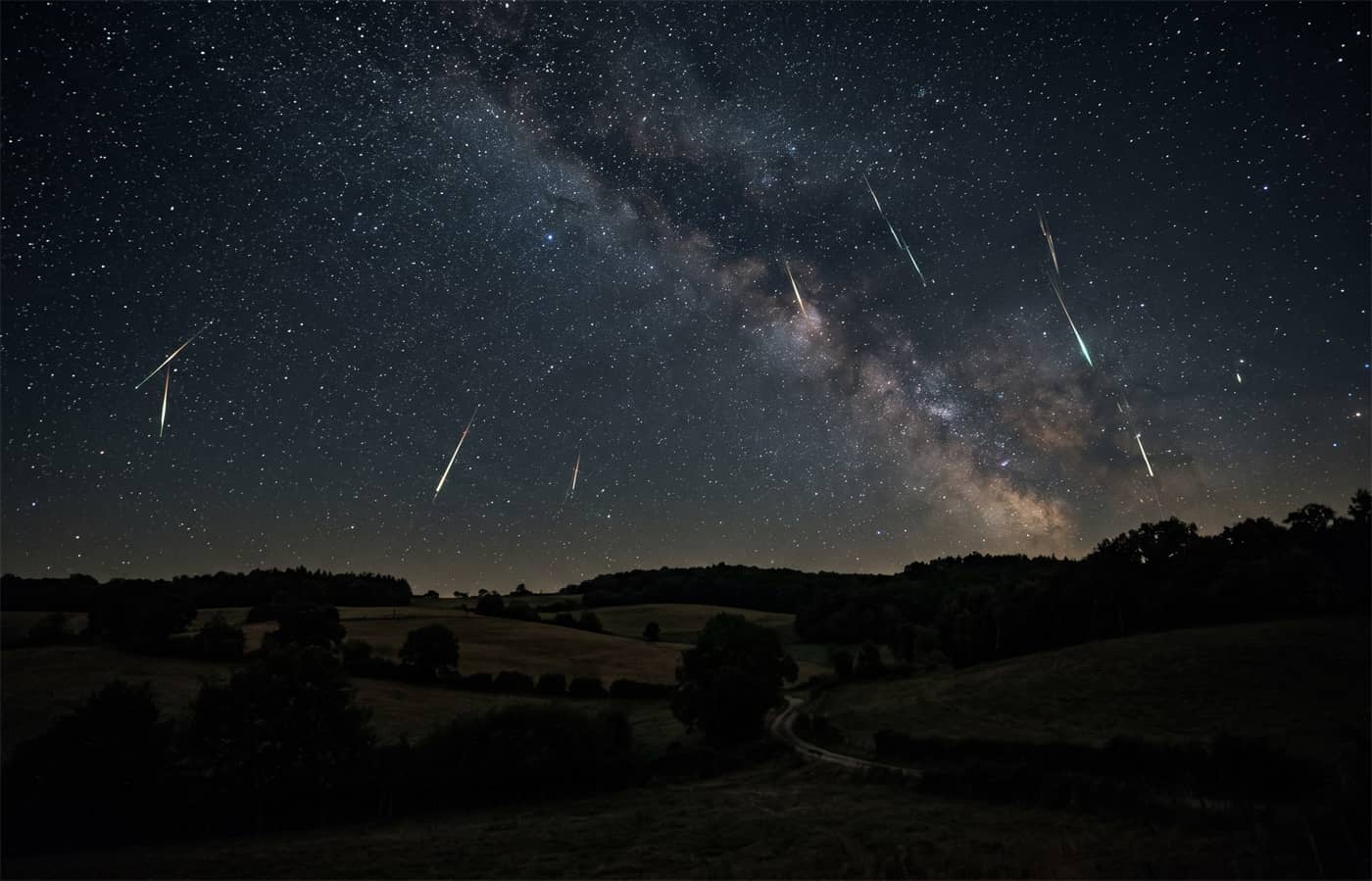 La Voie lactée et les Perséides traversant le ciel à la campagne (Crédit : Alex.I)
