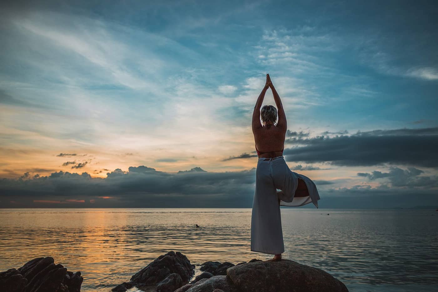 Une pose de yoga Asana au bord de la mer avec une femme (Crédit : Peggy_Marco)