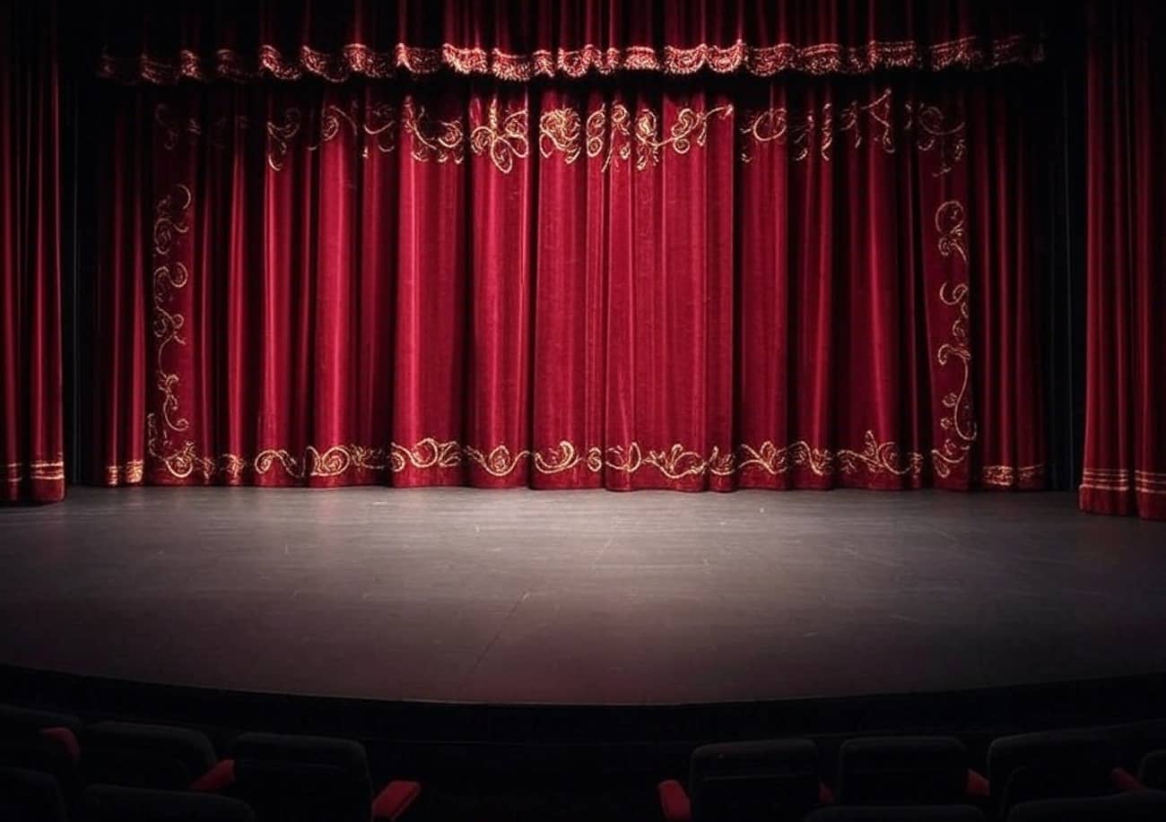 Une scène de théâtre où le rideau rouge est encore fermé (Crédit : Alex.I Grok)