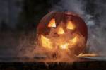 Citrouille d’Halloween lumineuse avec fumée dans la pénombre (Crédit : SzaboJanos)