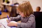 Un écolier dans une classe qui dessine (Crédit : Casyani)