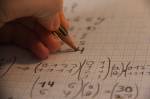 Un gaucher écrivant une solution à un problème de mathématique (Crédit : Dx21)