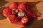 Un filet d’oranges gâtées sur une table en bois (Crédit : ShotRAV)