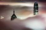 Des gratte-ciels dans les nuage en soirée (Crédit : Couleur)