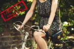 Une jeune fille en robe faisant du vélo (Crédit : Pexels)