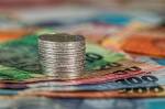 Pièces empilées sur des billets symbolisant les espèces (Crédit : Stevepb)