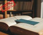 Un livre ouvert avec un marque-page (Crédit : Alex.I)