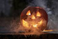Citrouille d’Halloween lumineuse avec fumée dans la pénombre (Crédit : SzaboJanos)