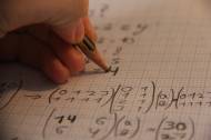 Un gaucher écrivant une solution à un problème de mathématique (Crédit : Dx21)