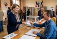 Une électrice remettant sa carte électorale à un assesseur (Crédit : Alex.I)