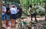 Un guide touristique dans la nature avec des touristes (Crédit : MemoryCatcher)