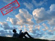 Une personne étendue sur l’herbe regardant les nuages  (Crédit : Alex.I Grok)