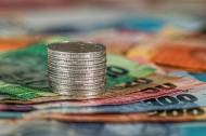 Pièces empilées sur des billets symbolisant les espèces (Crédit : Stevepb)
