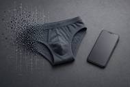 Un slip gris à côté d’un smartphone sur un fond gris (Crédit : Alex.I)